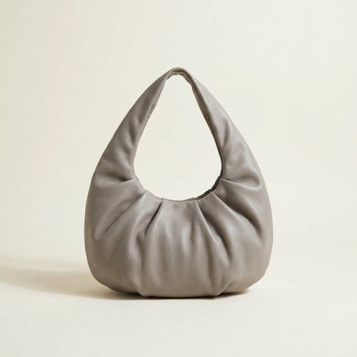 Camille soft cloud shoulder bag in warm dove grey against a cream studio backdrop