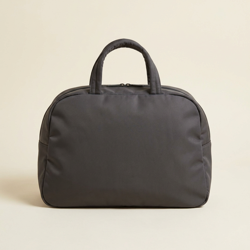 Harper zip-top carryall tote in deep charcoal, shown upright against a cream studio backdrop